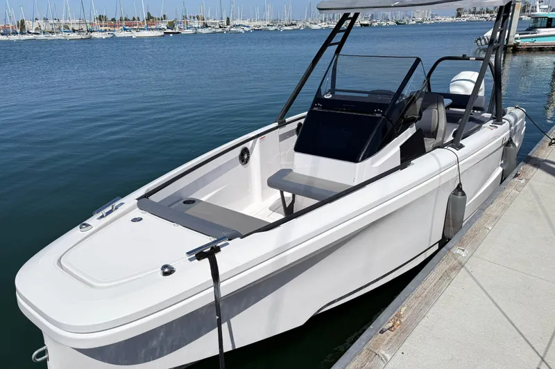 Slide: The Image of 2022 Axopar 22 T-Top boat docked at marina, showcasing sleek design and modern features. - 22