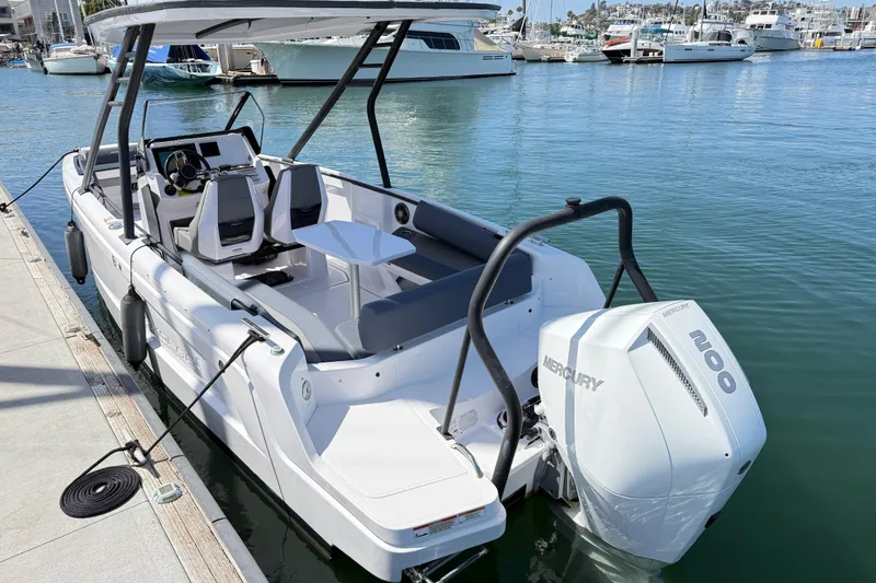 Slide: The Image of 2022 Axopar 22 T-Top boat docked, featuring a Mercury 200 engine, in a marina setting. - 23