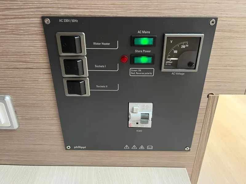 Slide: The Image of Control panel of a 2021 Hanse 418 yacht, featuring switches and voltage meter. - 35