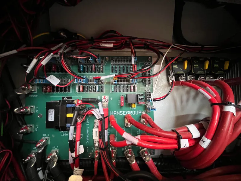 Slide: The Image of Electrical panel of a 2021 Hanse 418 yacht with red and black wiring. - 36