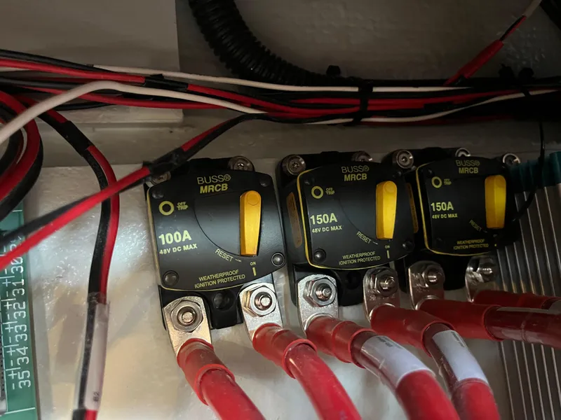 Slide: The Image of Electrical circuit breakers on a 2021 Hanse 418 yacht, featuring 100A and 150A ratings. - 37