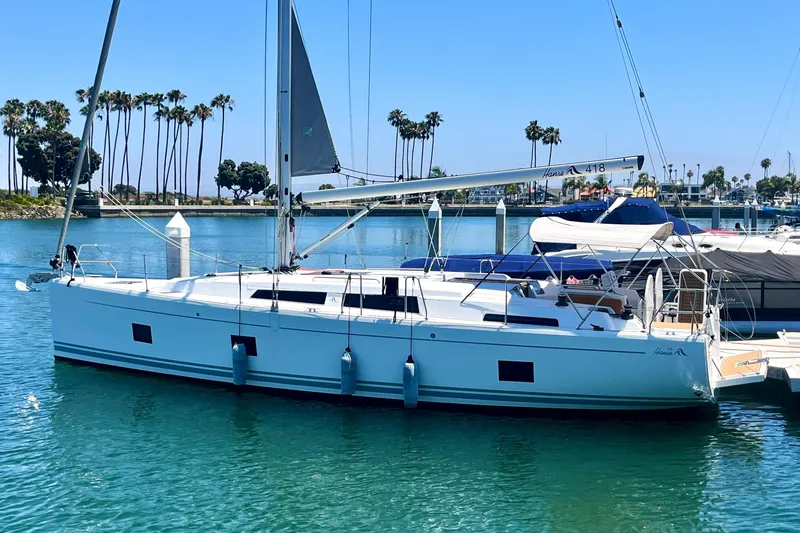 Slide: The Image of 2022 Hanse 418 sailboat docked in a marina with palm trees in the background. - 64