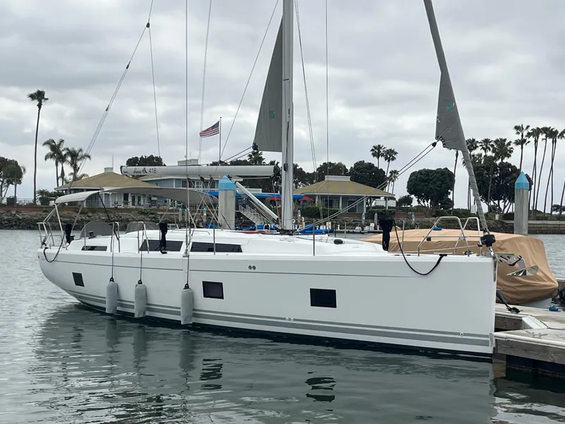 Slide: The Image of 2021 Hanse 418 yacht docked in a marina with palm trees and cloudy sky. - 7