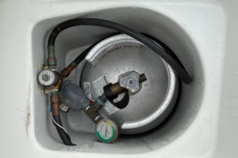 Slide: The Image of Propane tank setup in Ericson 32-200 sailboat, 1988 model, with connected hoses and gauge. - 13
