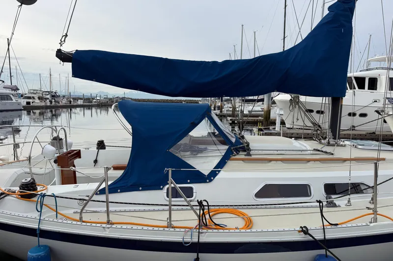 Slide: The Image of 1988 Ericson 32-200 sailboat docked at marina with blue sail cover. - 2