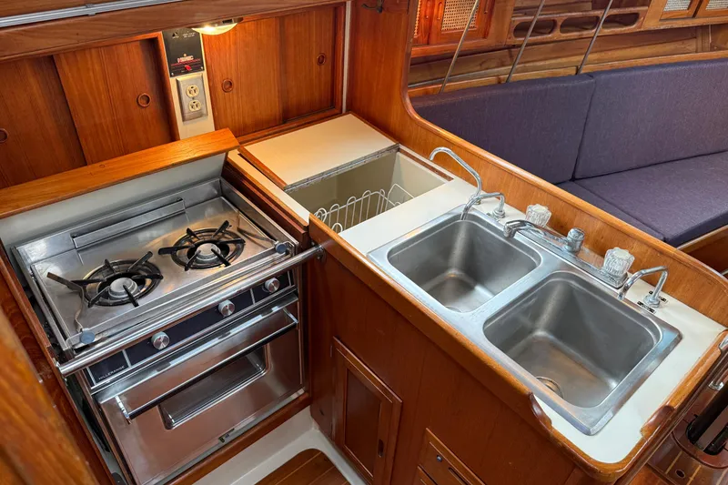 Slide: The Image of Compact galley kitchen in 1988 Ericson 32-200 sailboat with stove, double sink, and wood cabinetry. - 22