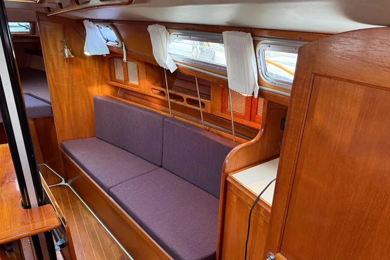 Slide: The Image of Interior of 1988 Ericson 32-200 sailboat with wooden finish and purple seating. - 24