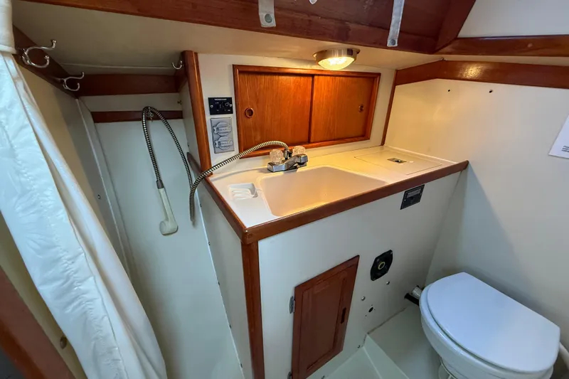 Slide: The Image of Compact bathroom in 1988 Ericson 32-200 sailboat with sink, toilet, and wooden cabinetry. - 30