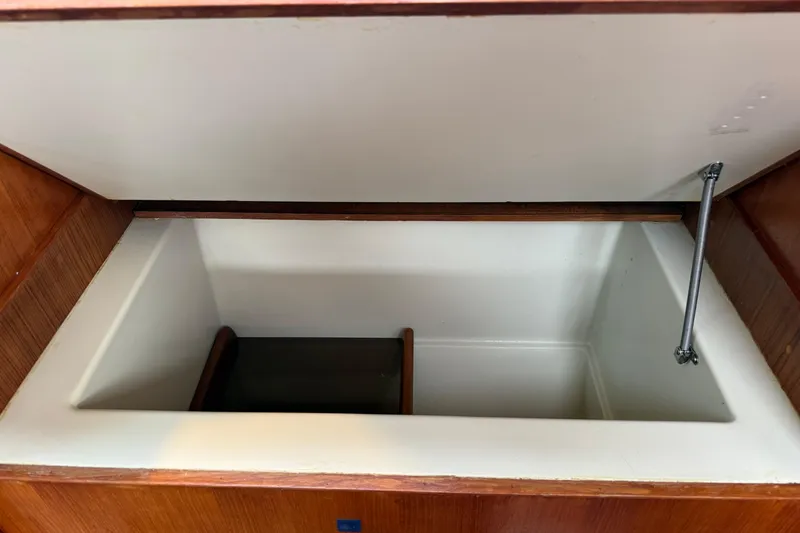 Slide: The Image of Open storage compartment inside 1988 Ericson 32-200 sailboat, featuring wooden trim and hydraulic support. - 37