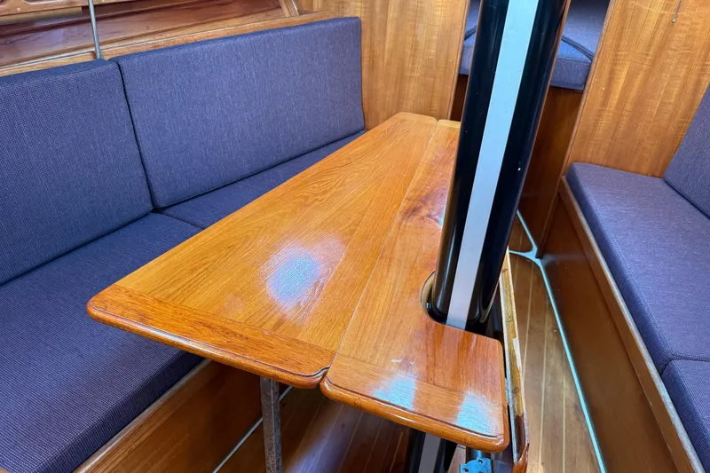 Slide: The Image of Interior of 1988 Ericson 32-200 sailboat with wooden table and blue cushioned seating. - 40