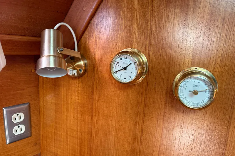Slide: The Image of Brass clock and barometer on wooden panel in 1988 Ericson 32-200 sailboat interior. - 42