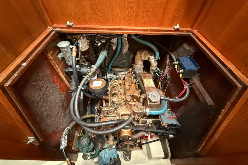 Slide: The Image of Engine compartment of a 1988 Ericson 32-200 sailboat, showcasing mechanical components and wiring. - 44