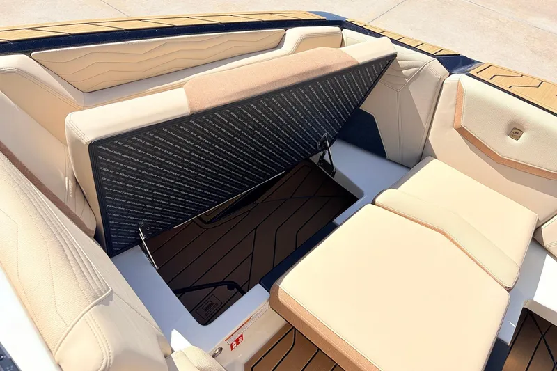 Slide: The Image of 2026 Nautique Super Air Nautique G23 interior seating with storage compartment open. - 22