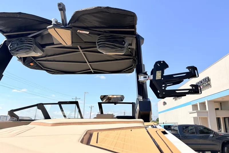 Slide: The Image of 2026 Nautique Super Air Nautique G23 boat with speakers and wakeboard rack, sunny day. - 70
