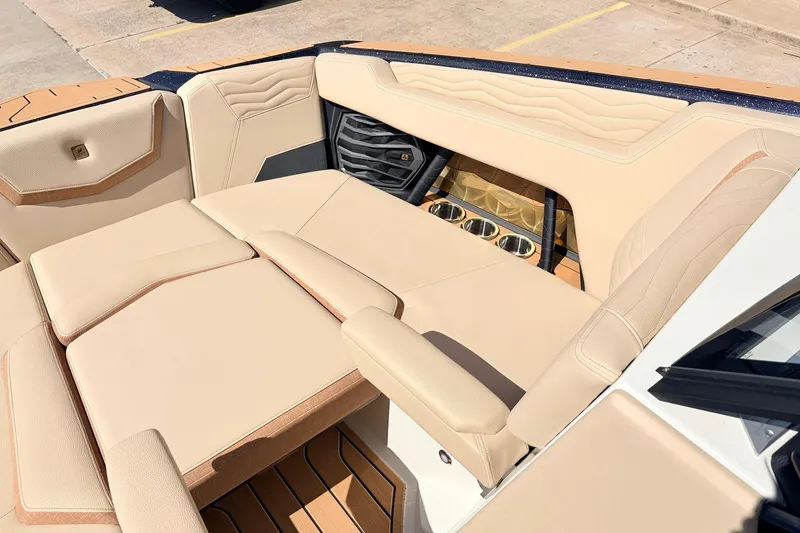 Slide: The Image of Luxurious interior of 2026 Nautique Super Air Nautique G23 with beige seating and cup holders. - 17