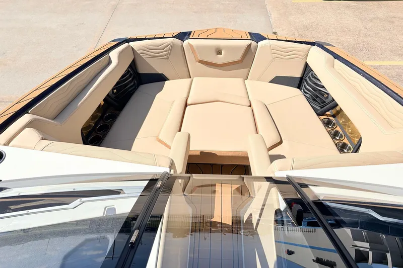 Slide: The Image of 2026 Nautique Super Air Nautique G23 boat interior with luxurious beige seating and cup holders. - 14