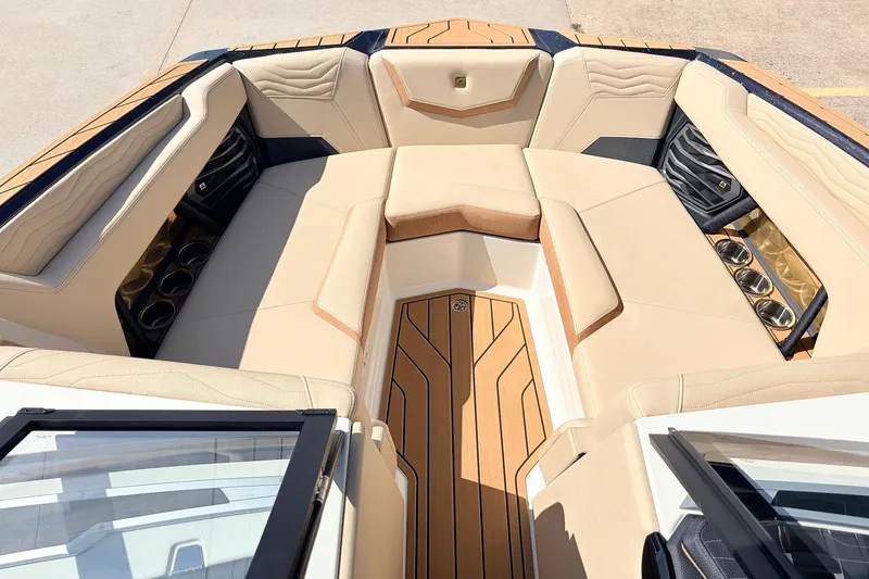 Slide: The Image of Luxurious interior of 2026 Nautique Super Air Nautique G23 boat with beige seating and cup holders. - 24