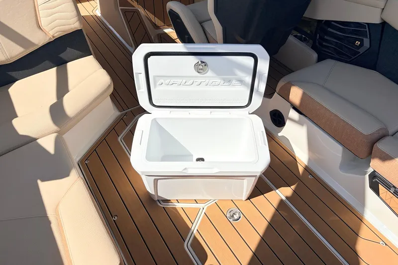 Slide: The Image of 2026 Nautique Super Air Nautique G23 interior with open cooler on teak deck. - 57