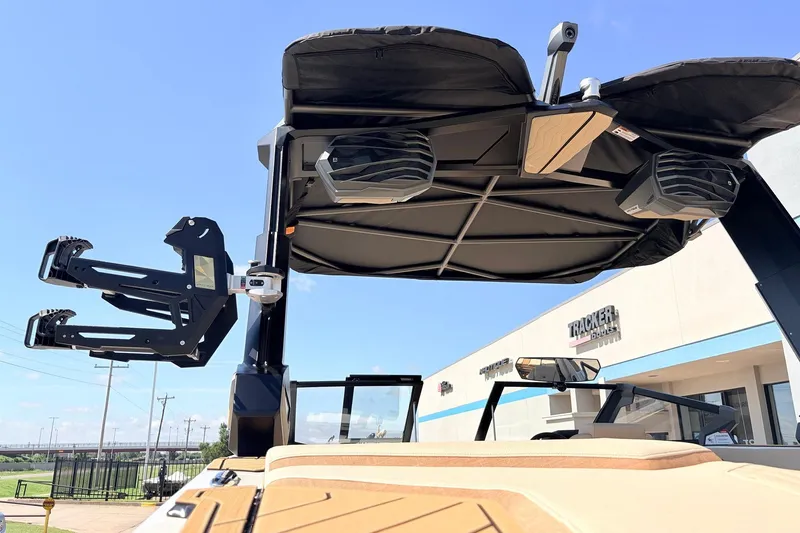 Slide: The Image of 2026 Nautique Super Air Nautique G23 boat with speakers and wakeboard rack, displayed outdoors. - 69