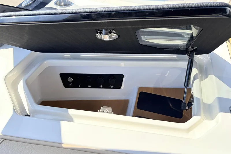 Slide: The Image of 2026 Nautique Super Air Nautique G23 storage compartment with control panel and hydraulic lift. - 30