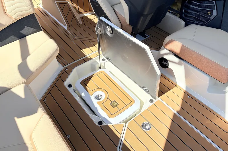Slide: The Image of 2026 Nautique Super Air Nautique G23 interior with open storage compartment and teak flooring. - 55