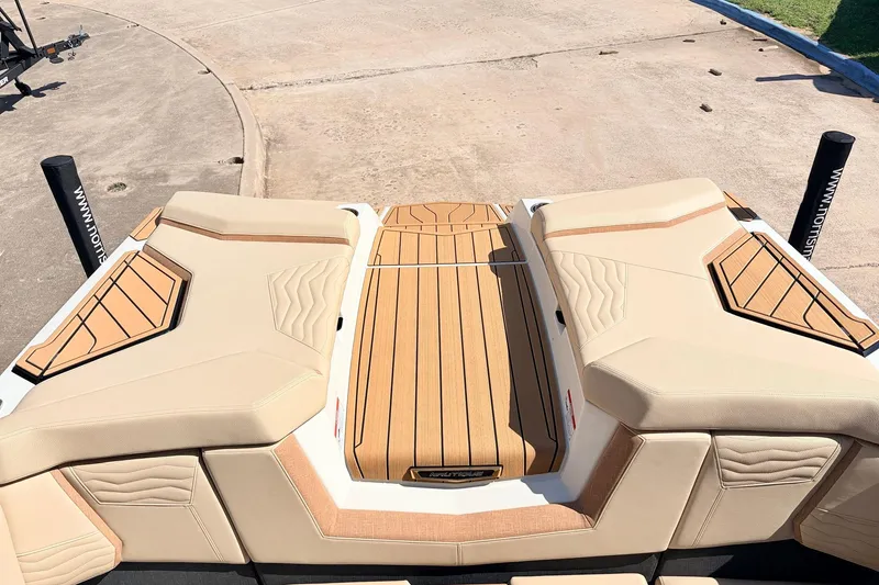 Slide: The Image of 2026 Nautique Super Air Nautique G23 boat deck with beige upholstery and wood accents. - 59