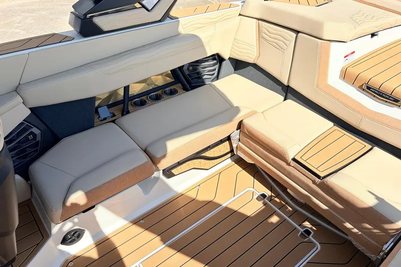 Slide: The Image of 2026 Nautique Super Air Nautique G23 interior with luxurious tan seating and cup holders. - 44