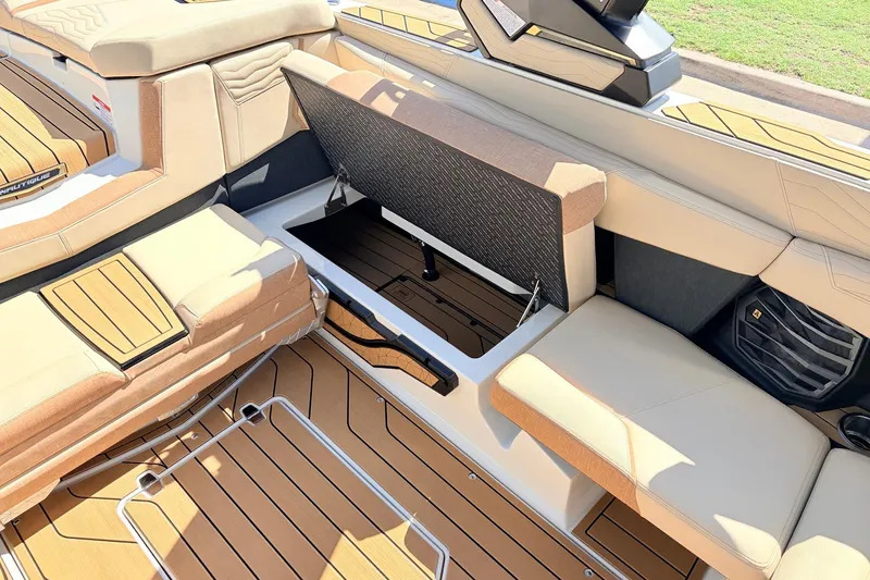Slide: The Image of 2026 Nautique Super Air Nautique G23 interior with open storage compartment and cushioned seating. - 36