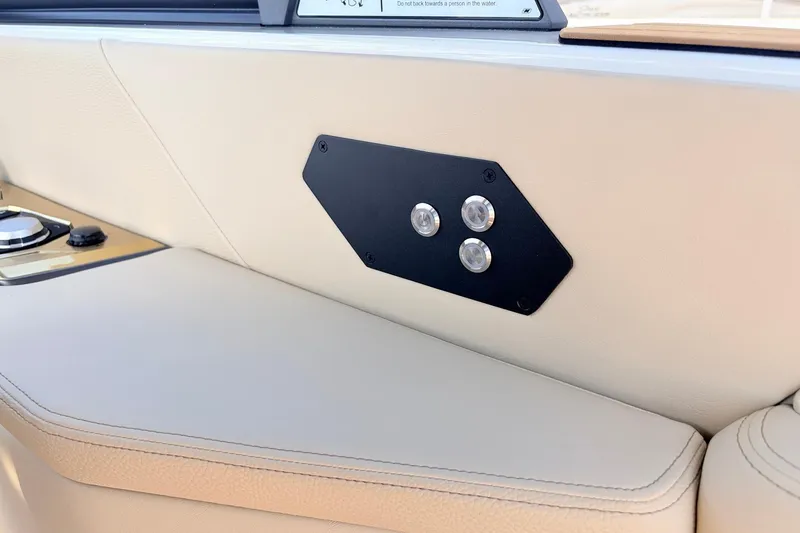 Slide: The Image of Interior detail of 2026 Nautique Super Air Nautique G23 boat, featuring beige upholstery and control panel. - 53