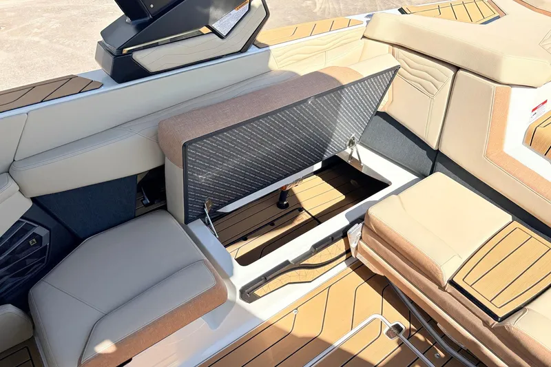 Slide: The Image of 2026 Nautique Super Air Nautique G23 interior with open storage compartment and beige seating. - 45