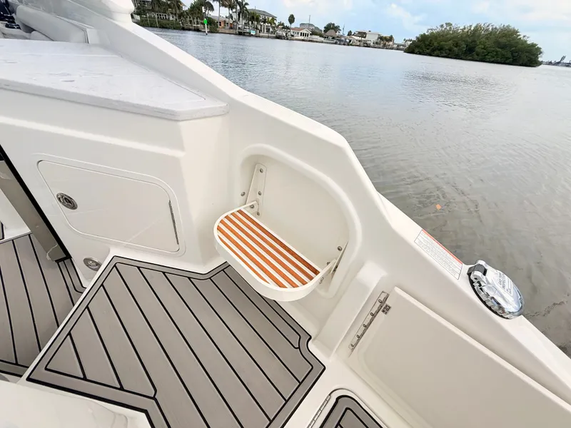 Slide: The Image of The image shows the stern of a 2027 Sea Ray SDX 290 Outboard with a fold-down seat and gray flooring. - 34