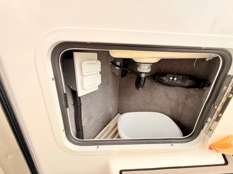 Slide: The Image of A storage compartment inside a 2027 Sea Ray SDX 290 Outboard with cables and a container. - 37
