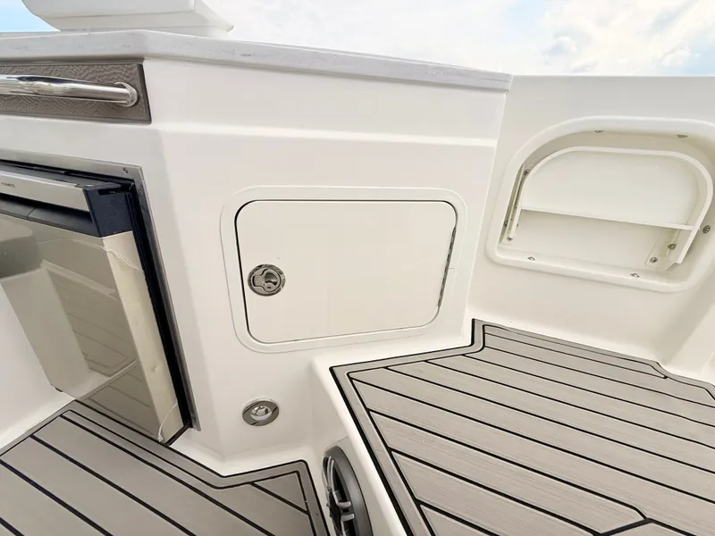 Slide: The Image of The image shows the deck of a 2027 Sea Ray SDX 290 Outboard with storage and a refrigerator. - 36