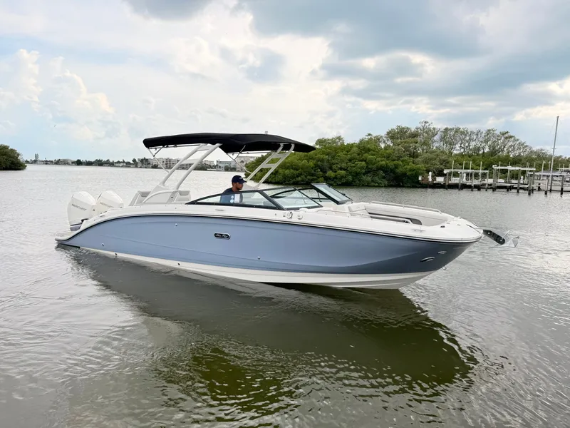 Slide: The Image of A sleek 2027 Sea Ray SDX 290 Outboard boat on calm water with a black canopy. - 9