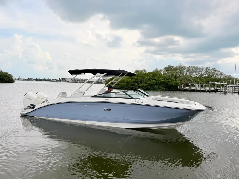 Slide: The Image of A sleek 2027 Sea Ray SDX 290 Outboard boat on calm water with a black canopy. - 10