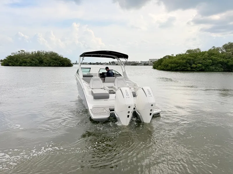 Slide: The Image of A 2027 Sea Ray SDX 290 Outboard cruising on calm water. It features twin outboard engines. - 19