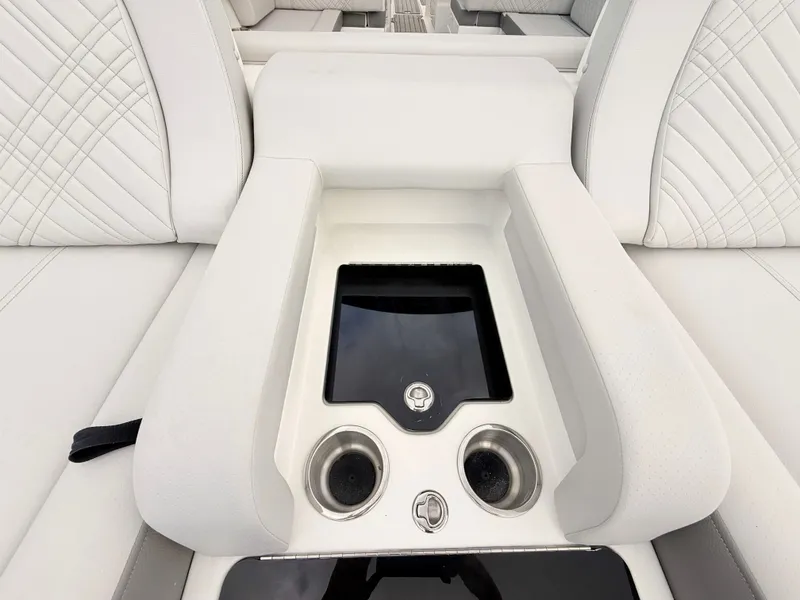 Slide: The Image of The image shows a sleek white seating area with built-in cup holders and a small screen. - 29
