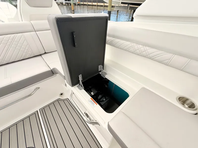 Slide: The Image of The image shows the seating area of a Sea Ray SDX 290 Outboard with an open storage compartment. - 42