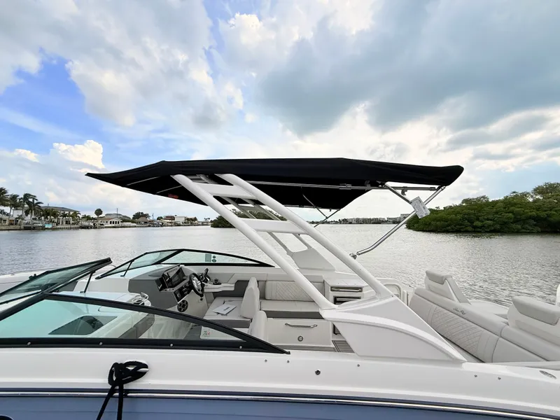 Slide: The Image of A 2027 Sea Ray SDX 290 Outboard with a black sunshade, situated on calm waters. - 22