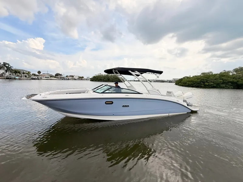 Slide: The Image of A sleek 2027 Sea Ray SDX 290 Outboard boat cruising on calm water under a cloudy sky. - 2