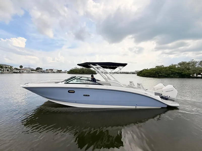 Slide: The Image of A sleek 2027 Sea Ray SDX 290 Outboard boat on calm water with a black sunshade. - 1