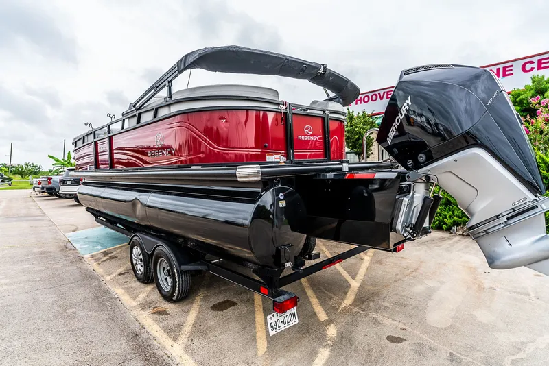 Slide: The Image of A 2022 Regency R230 DL3 pontoon boat on a trailer, featuring an outboard motor. - 4