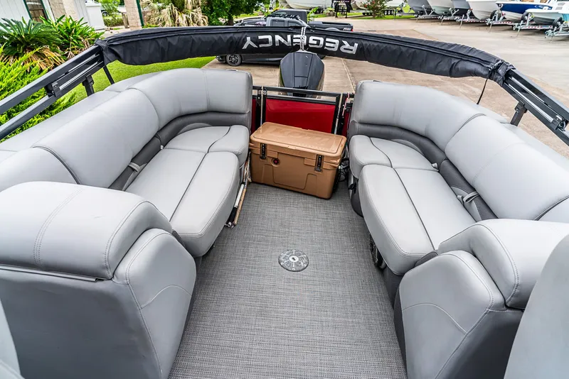 Slide: The Image of The image shows the interior of a Regency R230 DL3 pontoon boat with gray seating and a table. - 10