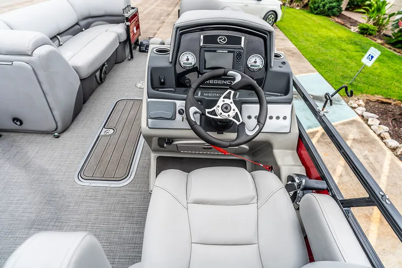 Slide: The Image of The image shows the cockpit of a 2022 Regency R230 DL3 with gray seating and a modern helm. - 7