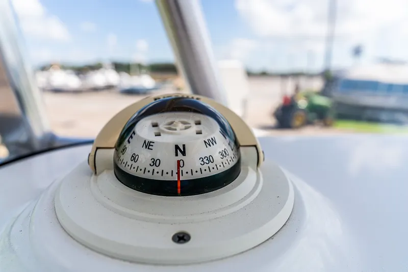 Slide: The Image of Close-up of a compass on a boat, with a blurred background. - 12
