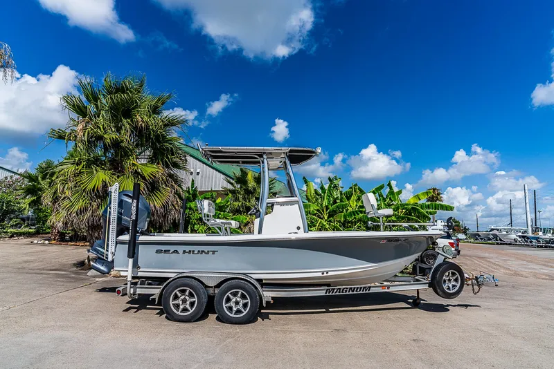 Slide: The Image of 2016 Sea Hunt BX 20 BR on a trailer, surrounded by palm trees and blue sky. - 2