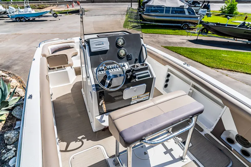 Slide: The Image of The image shows the cockpit of a 2016 Hurricane 21CC boat with a helm console and bench seat. - 6