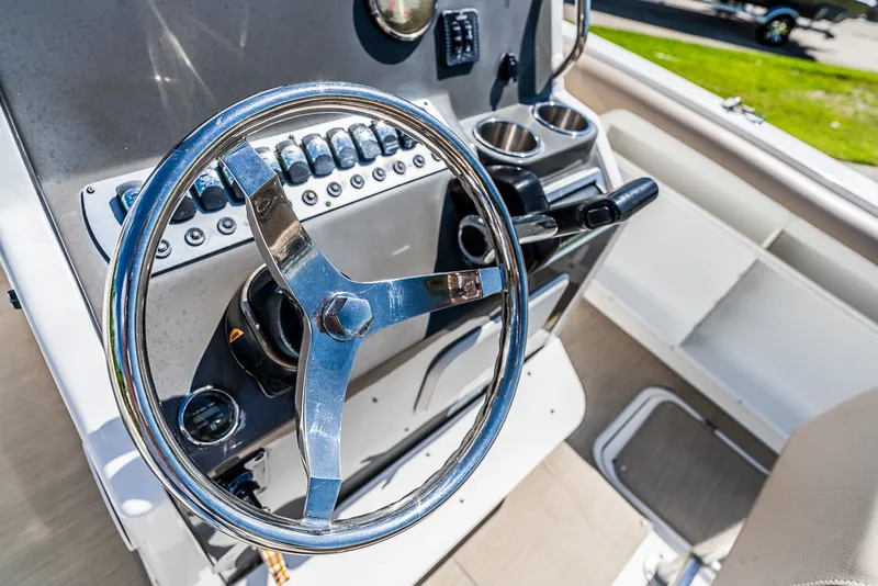 Slide: The Image of The image shows the helm of a 2016 Hurricane 21CC boat with a shiny steering wheel and instruments. - 9