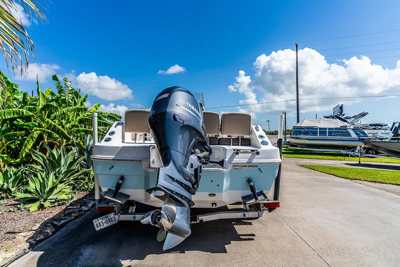 Slide: The Image of A 2016 Hurricane 21CC boat with an outboard motor, parked on a trailer. - 4