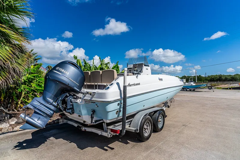 Slide: The Image of A 2016 Hurricane 21CC boat on a trailer, featuring a Yamaha outboard motor, parked on a lot. - 3